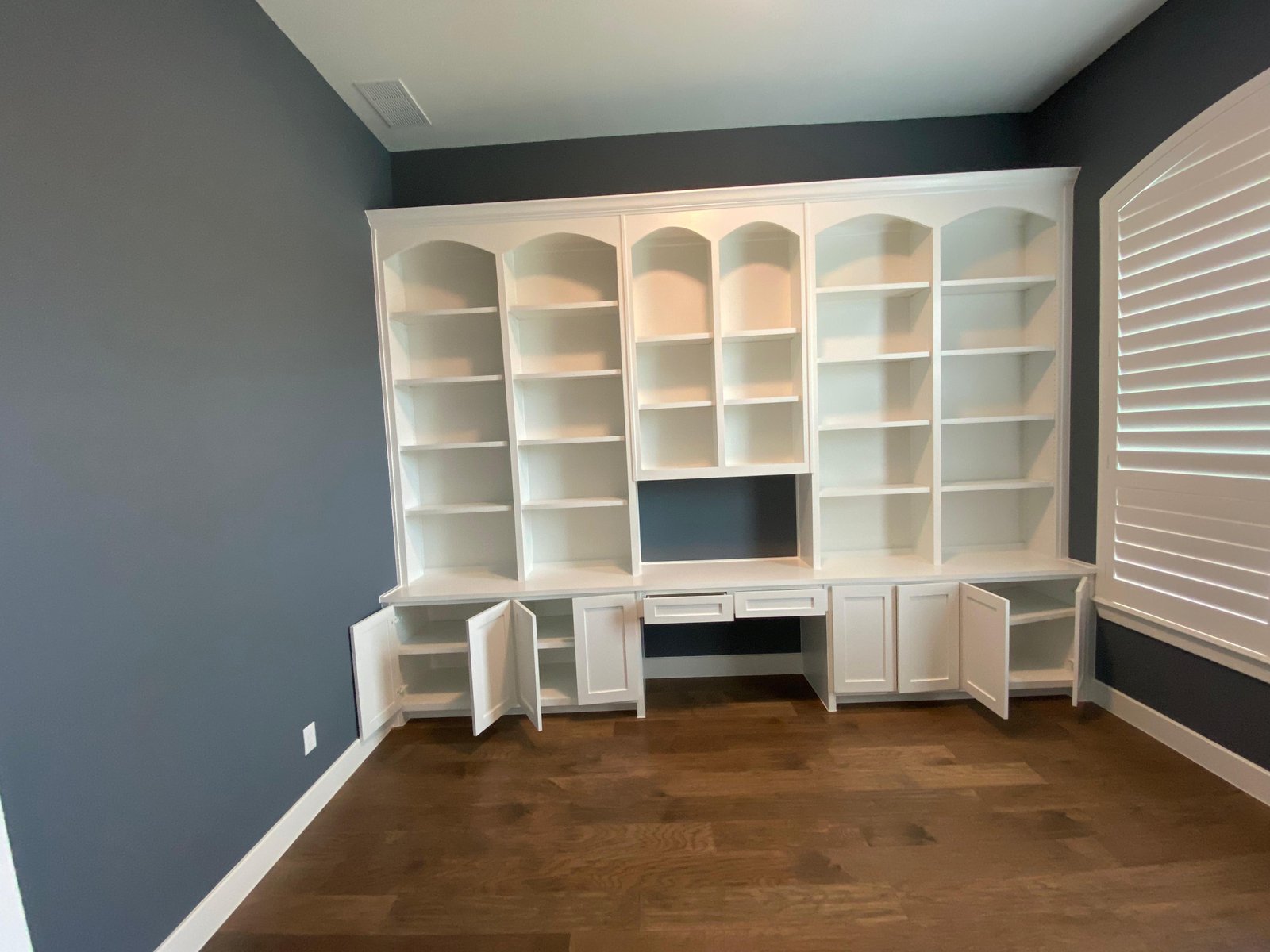 Custom builtin desk and bookshelves blue room