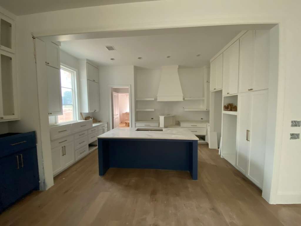 Kitchen with navy blue island and white cabinets